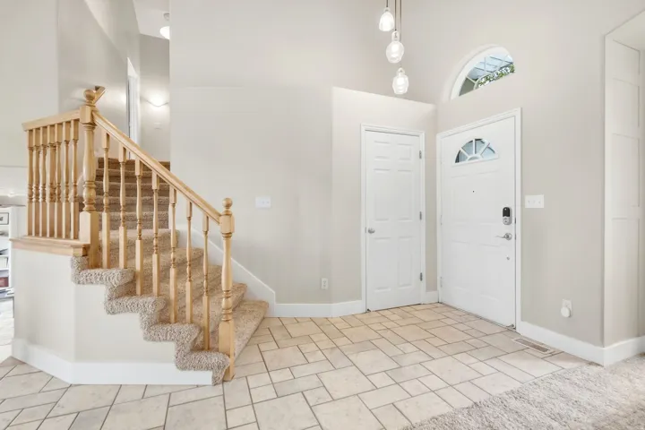 Front entry, coat closet, and stairs leading to upper levek