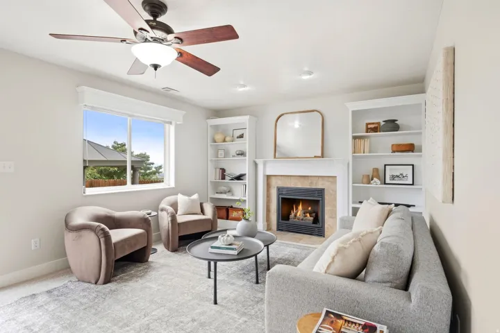 Lower living room off of the garage entrance with a gas fireplace, ample natural light, access to the back deck, and built-in shelving