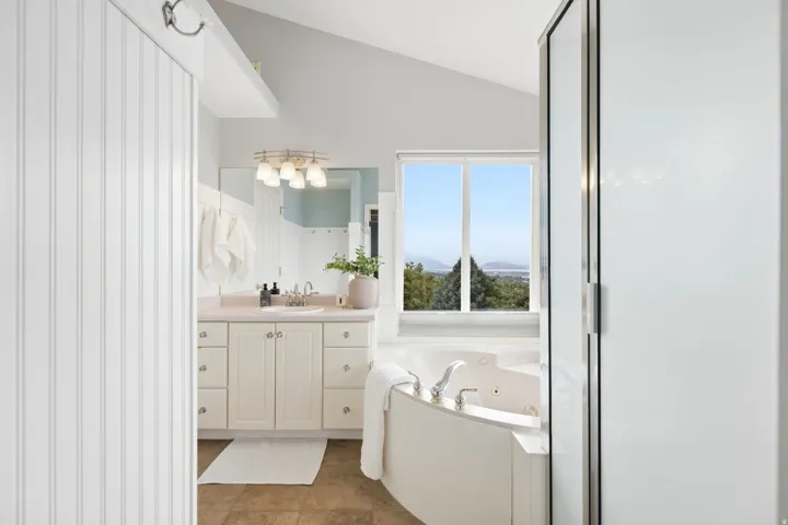 Large ensuite bathroom with separate soaking tub and shower and vaulted ceilings.