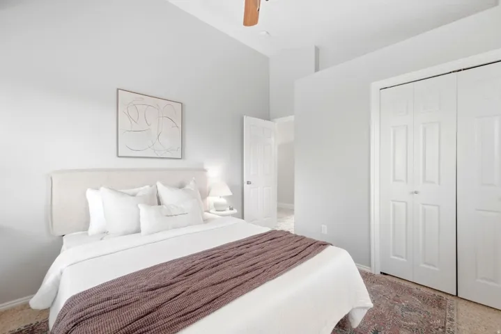 Second upstairs bedroom, across the hall from the primary bedroom, with vaulted ceilings and a cozy reading nook window seat.
