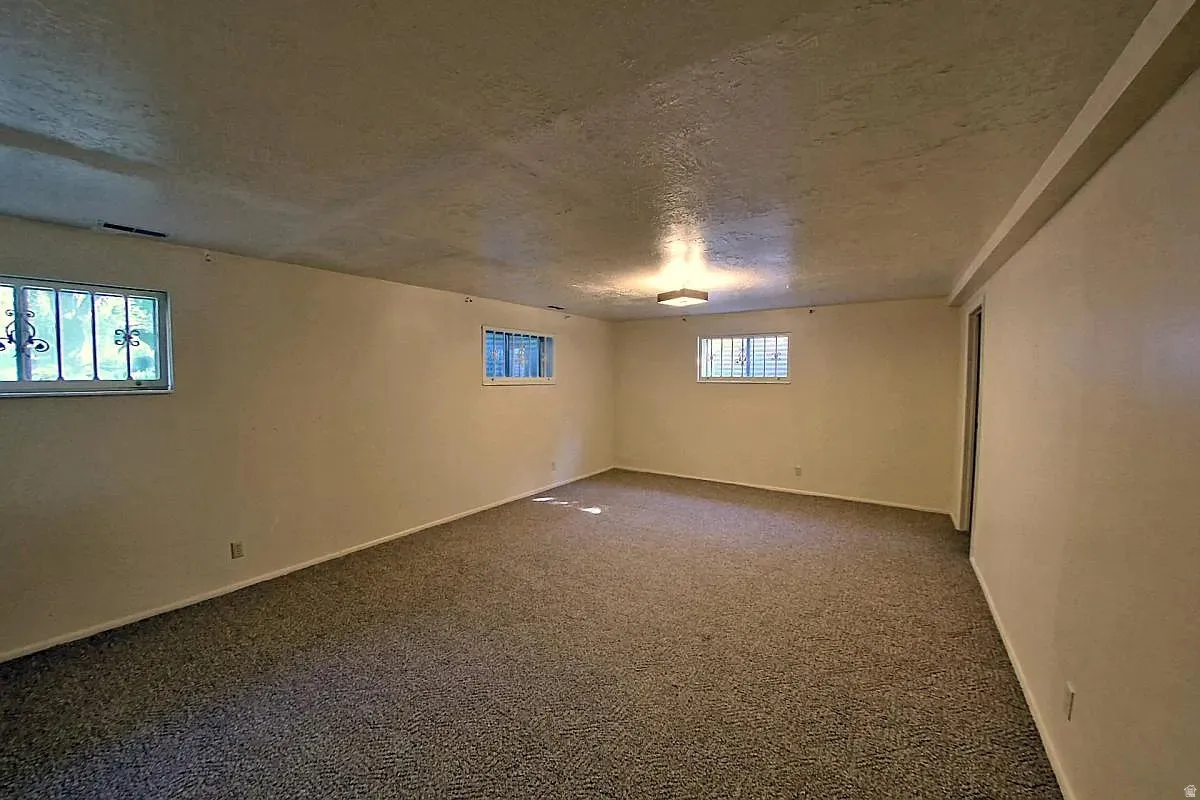 Carpeted room with multiple windows, recessed lighting, and neutral wall tones