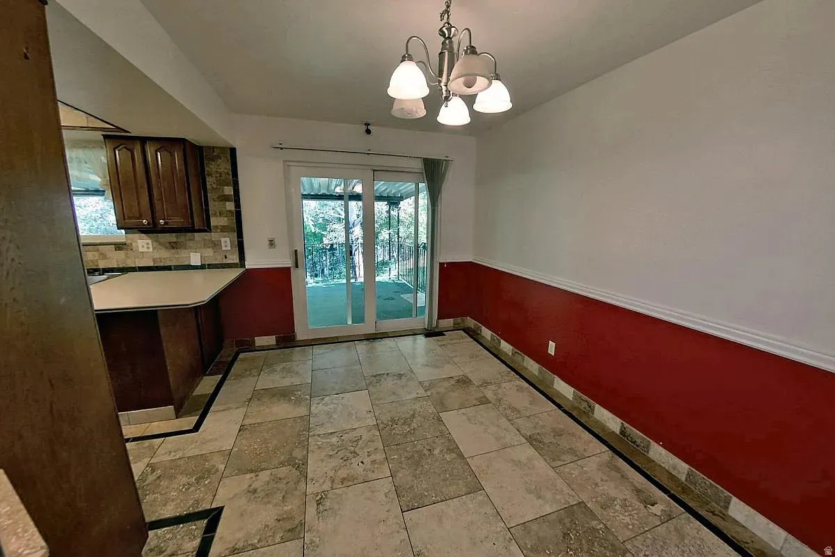 Ceramic tile flooring, sliding glass doors, built-in cabinetry, and a multi-light chandelier