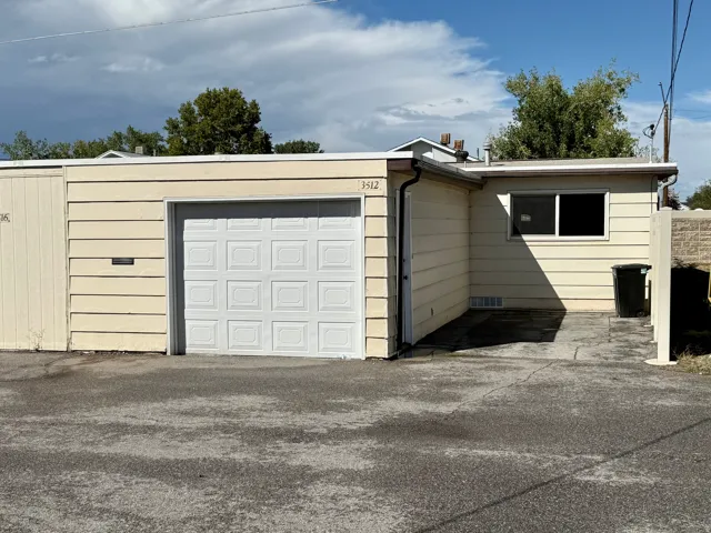 Back side of listed property.  Single-story structure with horizontal siding and a white paneled garage door