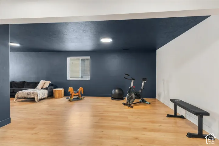 Spacious room featuring wood-finish flooring, recessed lighting, and a window