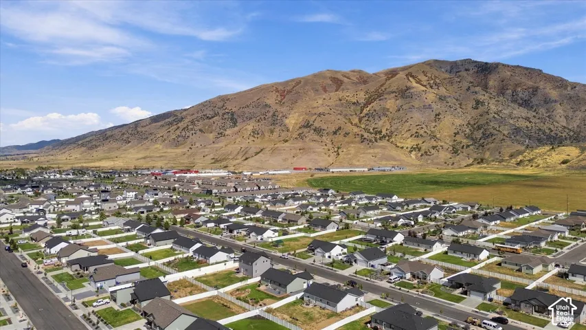 Expansive residential community with asphalt streets, manicured lawns, and adjacent mountainous terrain