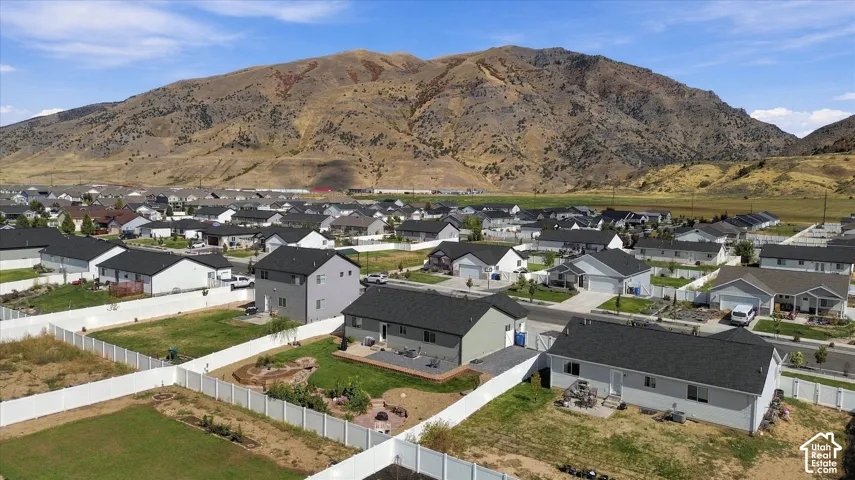 New construction community with uniform residential structures and surrounding mountain landscape