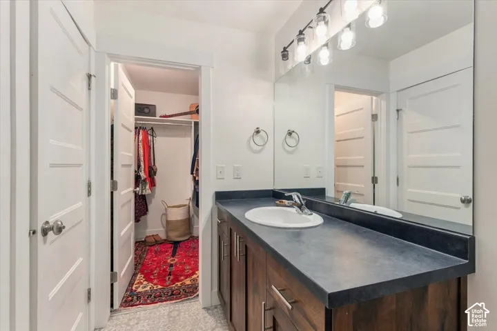 Wood-finish vanity with an integrated sink and dark countertop