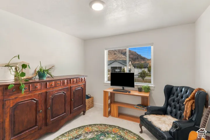 Recessed ceiling lighting, white walls, carpet flooring, a window with horizontal blinds, and a built-in wooden console table