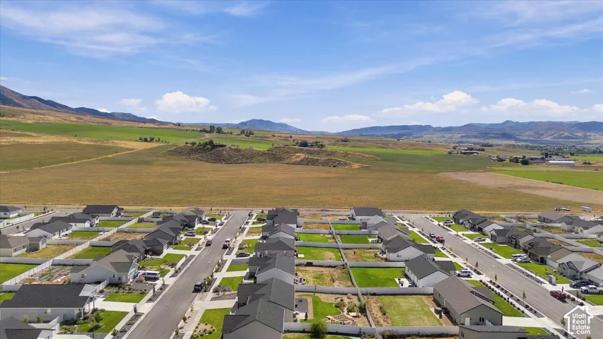 Expansive rural setting with a residential development featuring new construction homes, paved streets, and manicured lawns