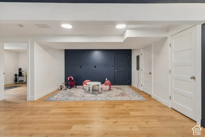 Recessed lighting illuminates wood-finish flooring
