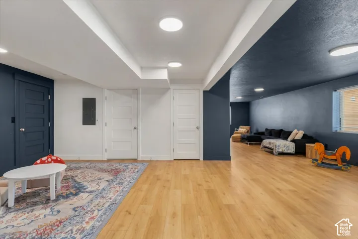 Expansive room featuring wood-finish flooring, recessed lighting, and multiple paneled doors