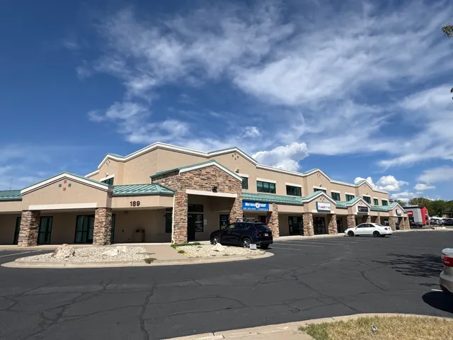Multi-unit commercial building featuring a stucco exterior, stone accents, and a distinctive roofline
