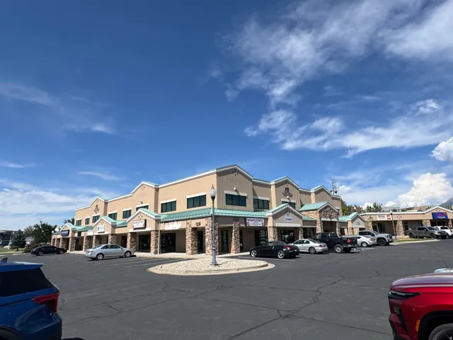 Commercial building with varied rooflines, stone-clad columns, and multiple storefronts