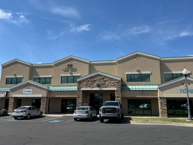Stucco exterior with stone accents, multiple large windows, and a prominent entry