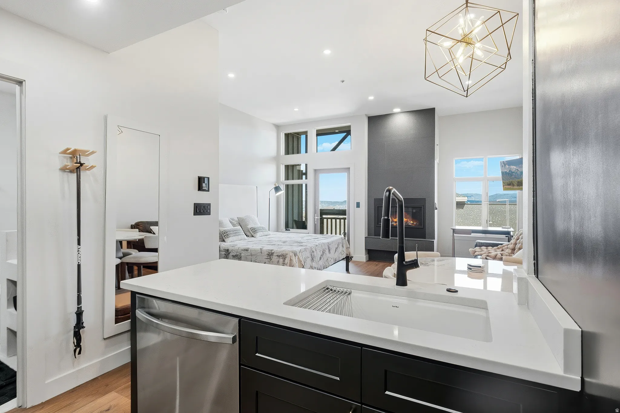 Modern kitchen featuring a white countertop with an undermount sink, a stainless steel dishwasher, and dark wood-finish cabinetry