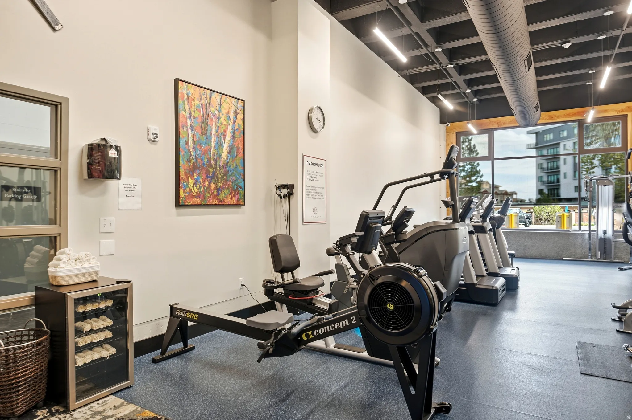 Fitness center featuring expansive floor-to-ceiling windows, exposed ductwork, recessed lighting, a rowing machine, and cardio equipment