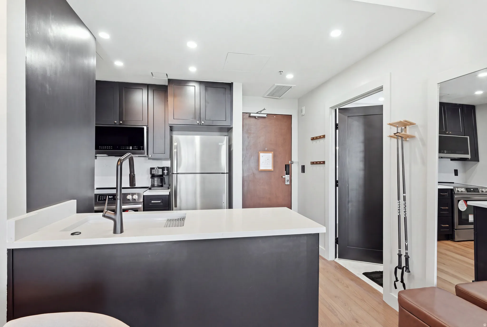 Kitchen featuring dark cabinetry, stainless steel appliances, a white countertop, and recessed lighting