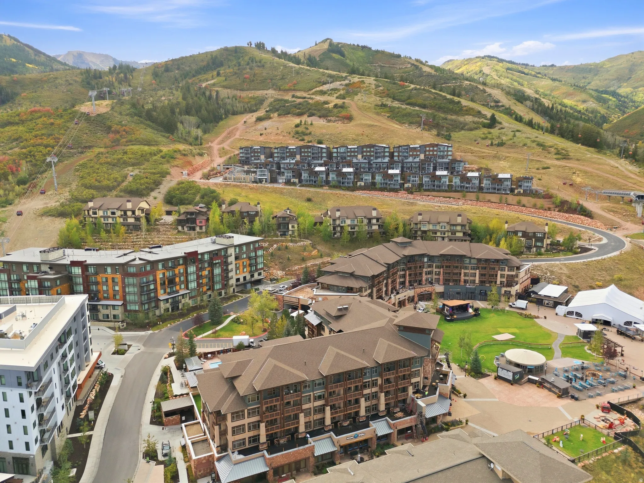 Mountainous topography, multi-story buildings, residential structures, paved roads, and green spaces