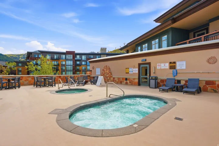 Rooftop terrace featuring two inground spas, lounge seating, and dining tables