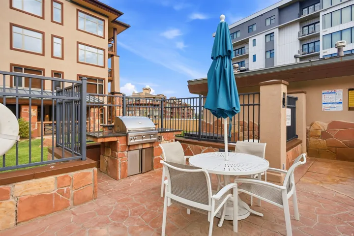Outdoor patio featuring a built-in stainless steel grill, stone-clad counter, and stamped concrete flooring
