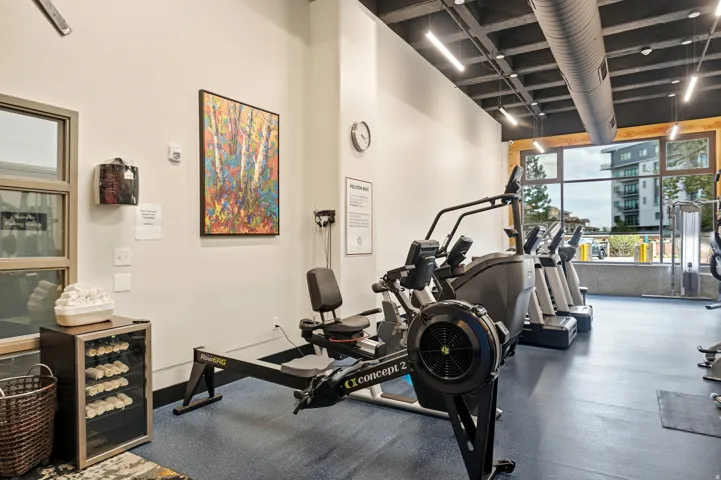 Fitness center featuring expansive floor-to-ceiling windows, exposed ductwork, recessed lighting, a rowing machine, and cardio equipment