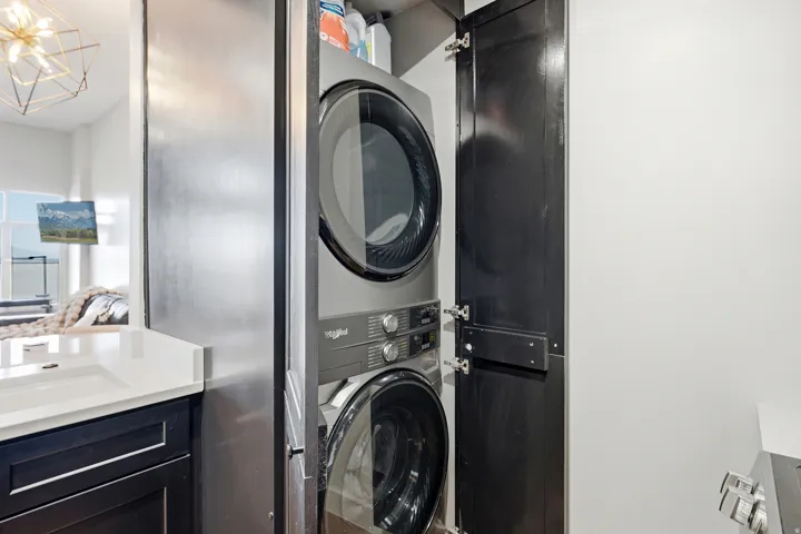 Integrated stackable washer and dryer within a dedicated utility cabinet