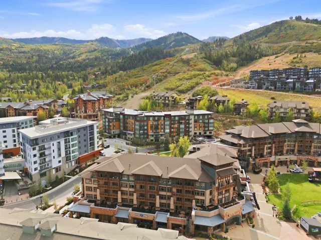 Mountainous terrain with natural landscaping, a collection of multi-story buildings, and paved roadways