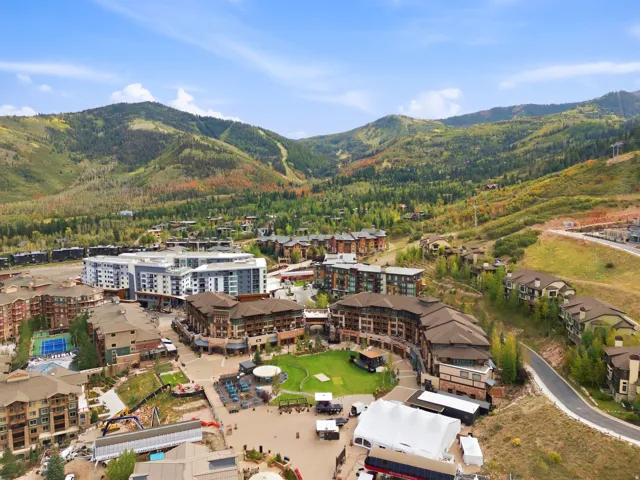 Mountainous backdrop with expansive green spaces and diverse architectural styles