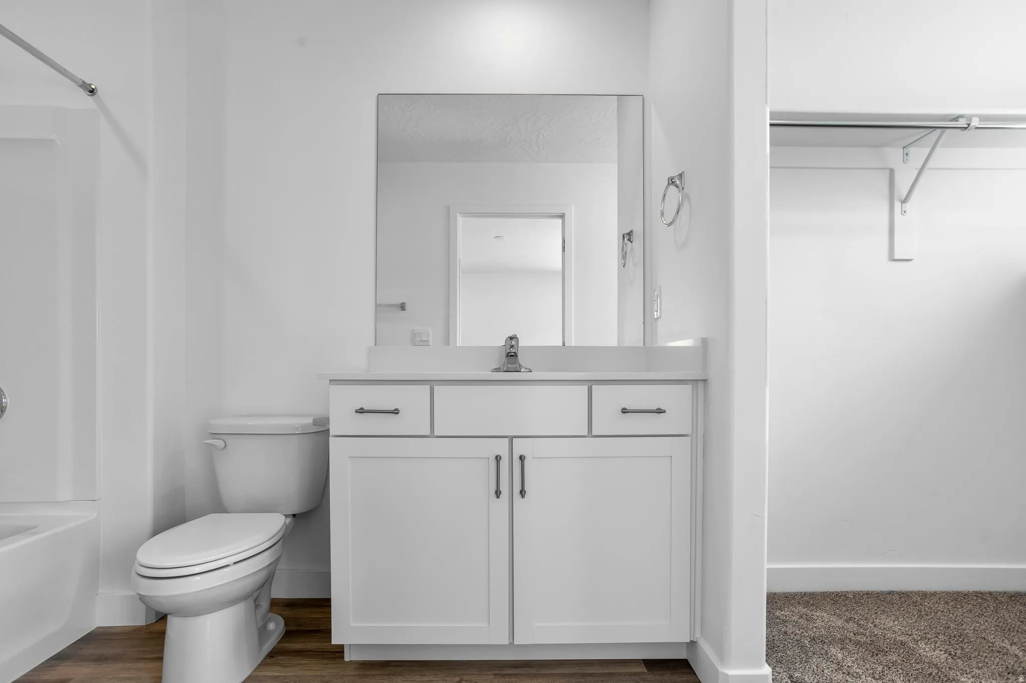White vanity with a light-colored countertop and integrated sink