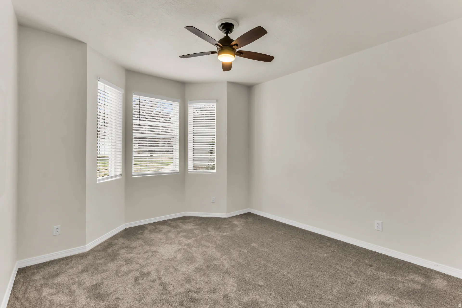 Bedroom 2 with bright recessed window alcove, and a ceiling fan.