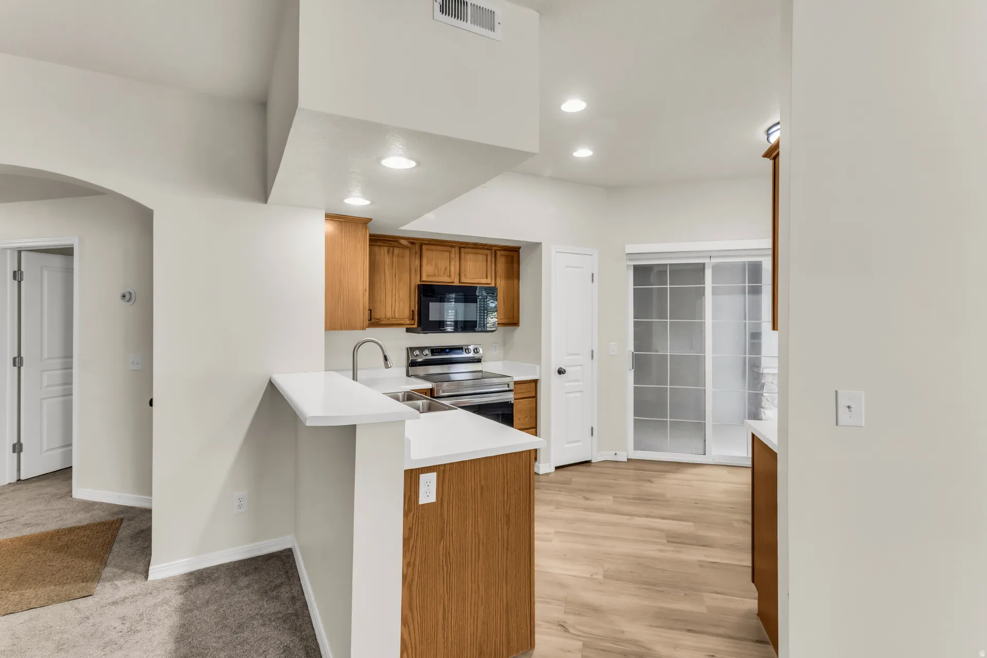 Kitchen view from dining area, patio is located outside sliding glass doors.