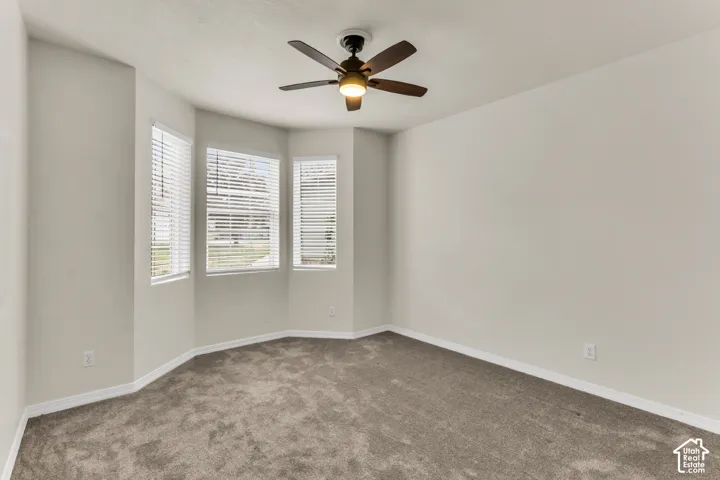 Bedroom 2 with bright recessed window alcove, and a ceiling fan.