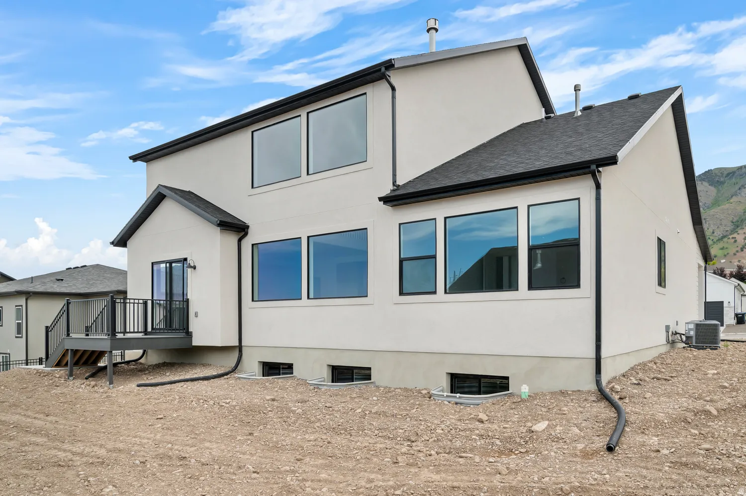 Contemporary stucco exterior with a dark asphalt shingle roof