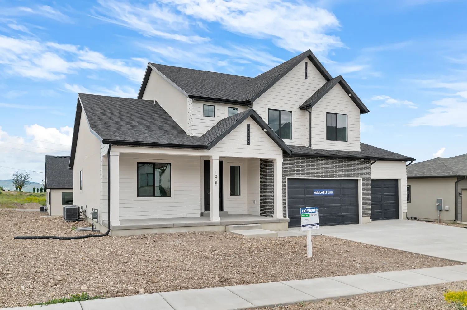 Contemporary exterior with black-framed windows, white siding, and a partial brick facade
