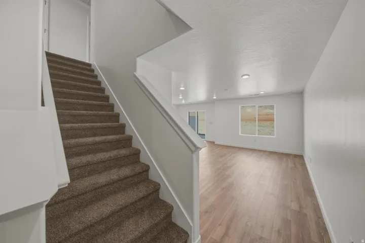 Open-concept living space featuring wood-finish flooring, recessed lighting, and large windows