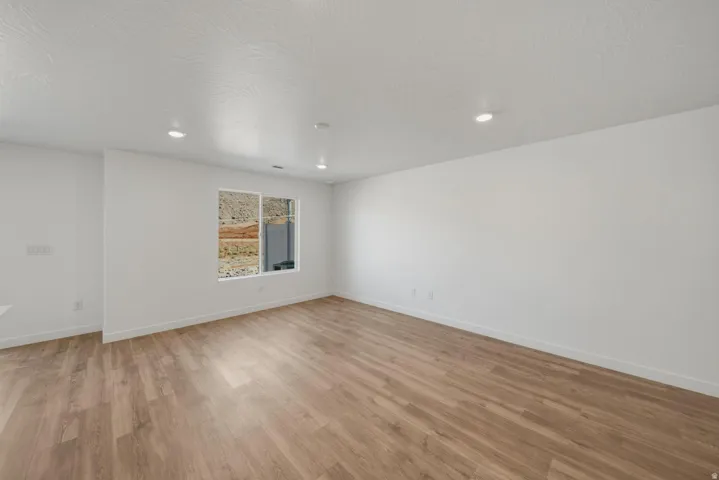 Recessed ceiling lighting, wood-finish flooring, and a large window