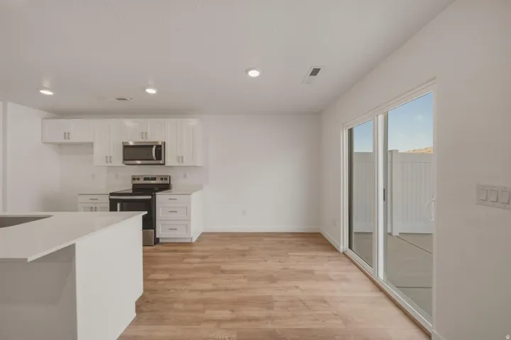 Kitchen featuring white cabinetry, stainless steel appliances, and a built-in island