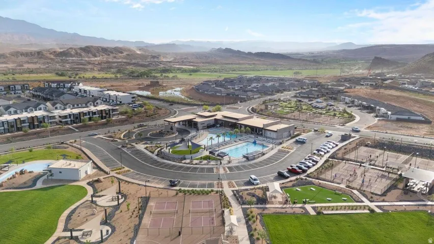 Community swimming pool with surrounding patio, multiple tennis courts, and expansive green spaces