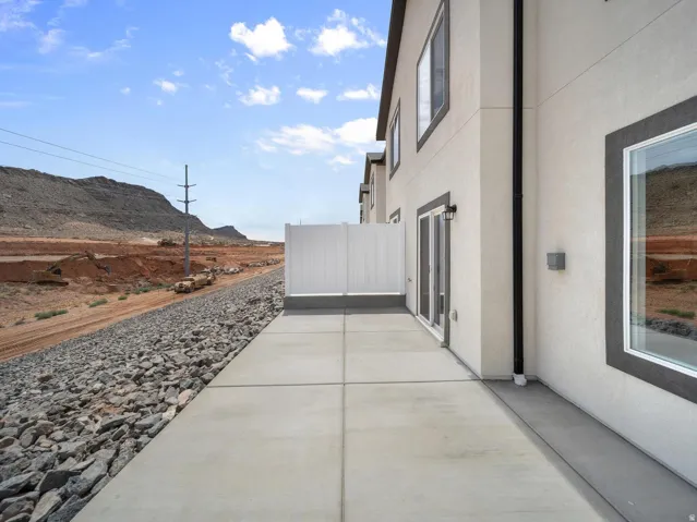 Concrete patio with a privacy fence, contemporary exterior lighting, and a sliding glass door