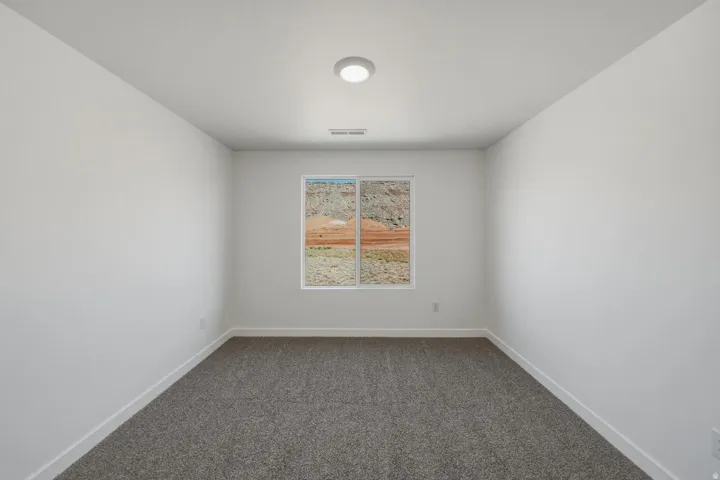 Neutral wall finish, recessed lighting, carpet flooring, and a single window