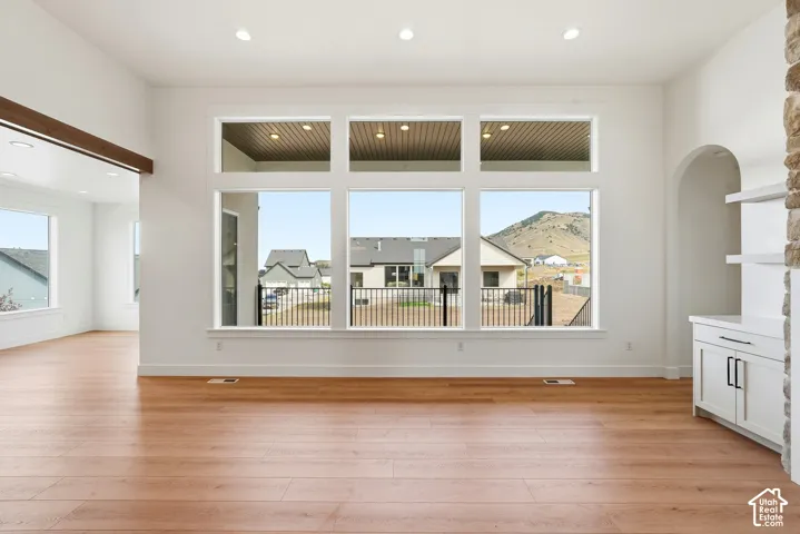 Expansive living area featuring wood-finish flooring, a wall of multi-pane windows, and recessed lighting
