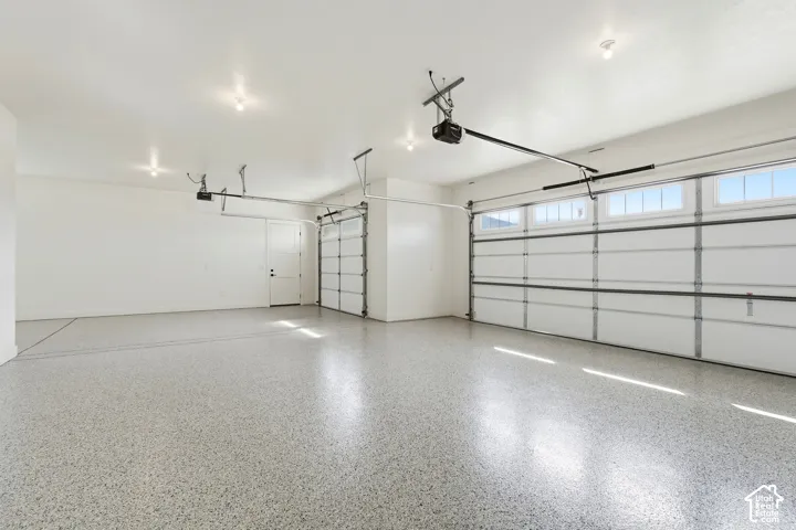 Epoxy-coated flooring, multiple overhead garage doors with transom windows, and recessed lighting