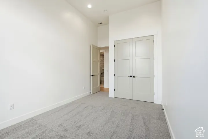 Neutral carpeting and a prominent closet with light-colored panel doors