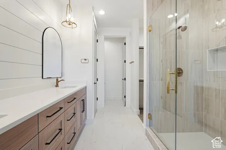 Walk-in shower with clear glass enclosure and tile surround