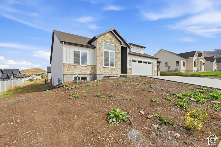 Stone and siding exterior with a dark shingle roof