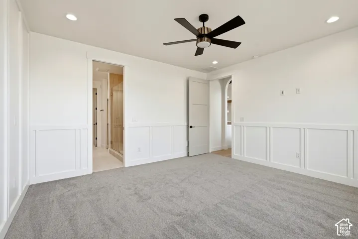 Wall paneling with a modern ceiling fan, recessed lighting, and soft gray carpeting
