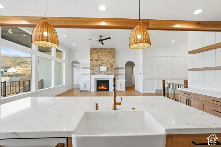 Kitchen island with a farmhouse sink, gold-finish faucet, and white countertop