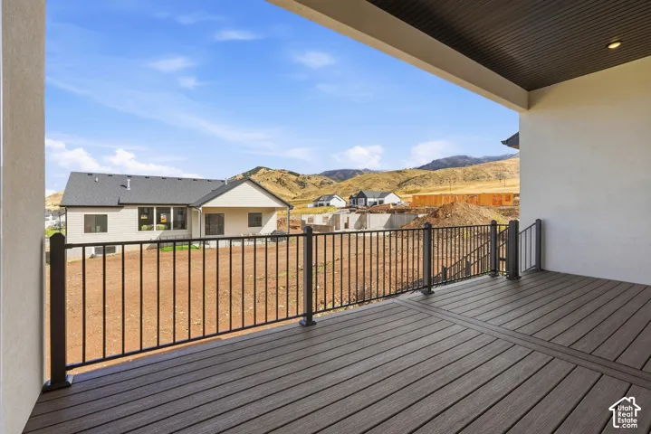 Spacious outdoor deck with composite decking, black metal railings, and a soffit ceiling with recessed lighting