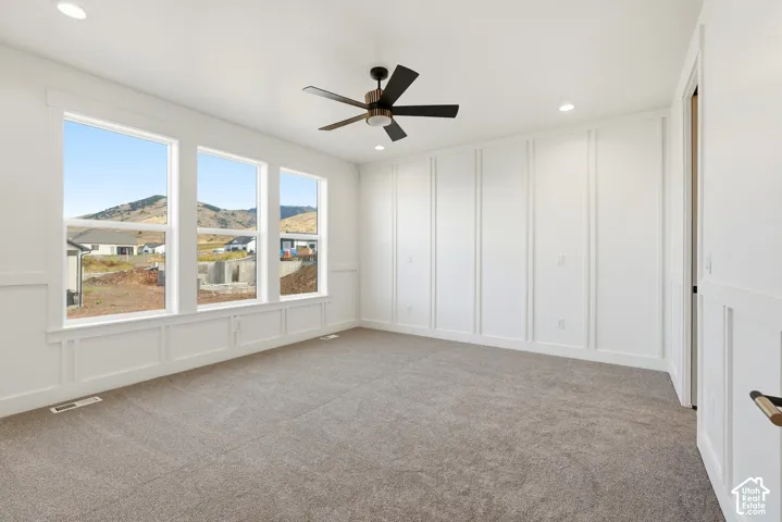 Triple windows, textured carpeting, recessed lighting, and a ceiling fan