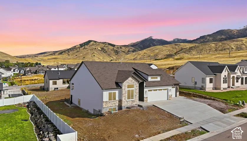 Modern residence featuring a neutral exterior, stone and siding accents, and an attached two-car garage
